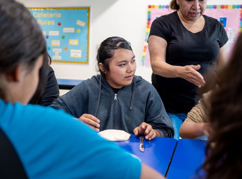 Student at table with dough